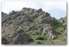 Характерный облик скал, торчащих по склонам гор и словно облитых чёрными натёками.